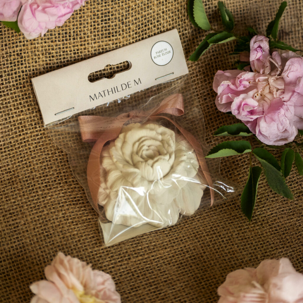 rose en plâtre blanc avec ruban rose décor parfumé rose élixir mathilde m